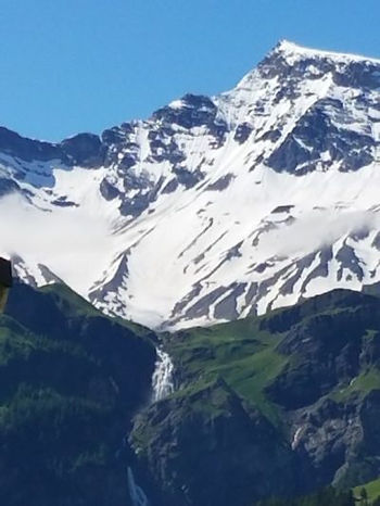 Very large snowfield hovers over the long drop of the Enslige Falls. The falls come down into the Frutigen Valley.